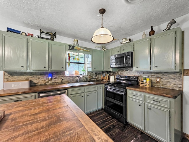 9378 Cocklebur Loop, Silsbee, TX 77656 - kitchen with butcher block counters, appliances with stainless steel finishes, green cabinetry, a textured ceiling, and dark wood-type flooring