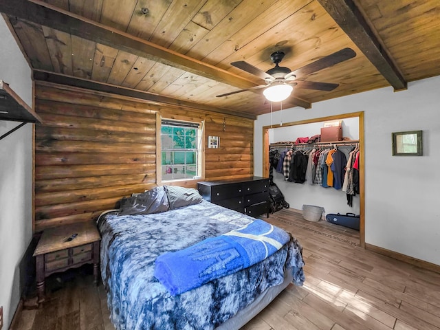 9378 Cocklebur Loop, Silsbee, TX 77656 - bedroom featuring a wooden ceiling with exposed beams, rustic walls, hardwood / wood-style floors, a ceiling fan, and a closet