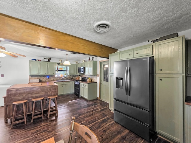 9378 Cocklebur Loop, Silsbee, TX 77656 - kitchen with green cabinets, stainless steel appliances, dark wood-style flooring, a ceiling fan, and a textured ceiling