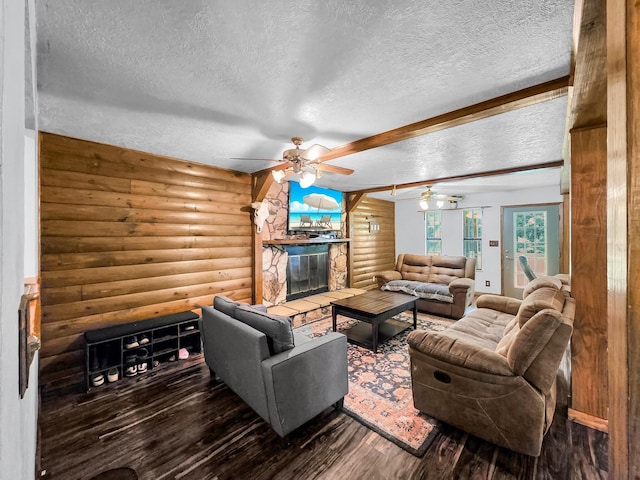 9378 Cocklebur Loop, Silsbee, TX 77656 - living area with log walls, a textured ceiling, wood finished floors, a ceiling fan, and a stone fireplace