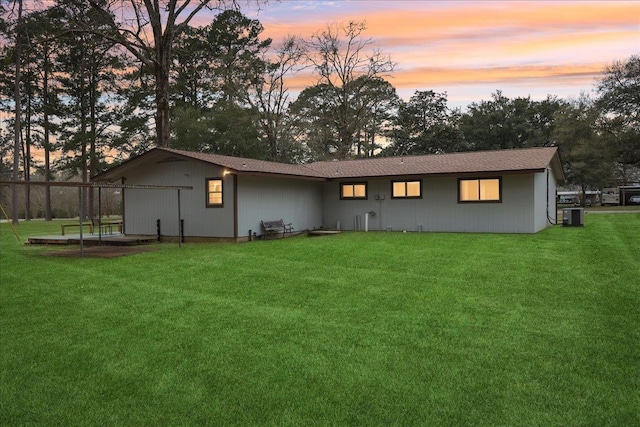 back of house at dusk featuring a yard