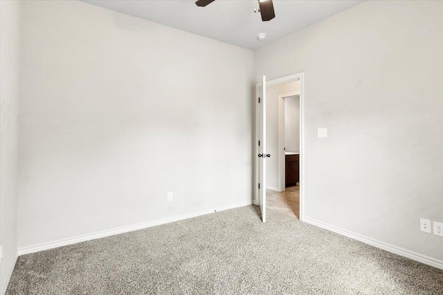 carpeted spare room with ceiling fan