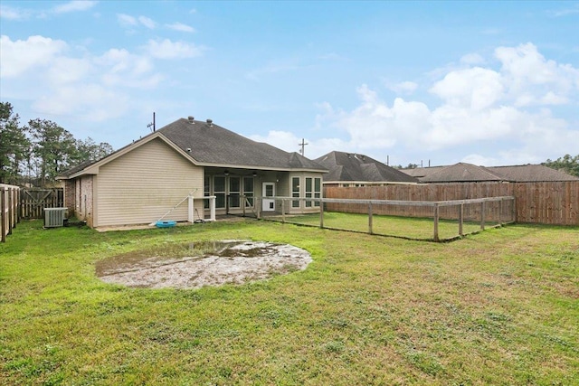 rear view of property featuring a lawn and central AC