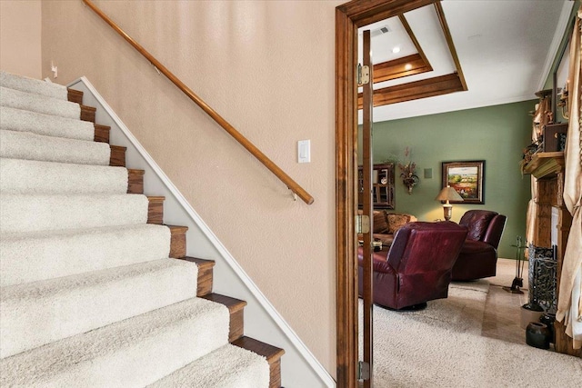 staircase featuring carpet floors and crown molding