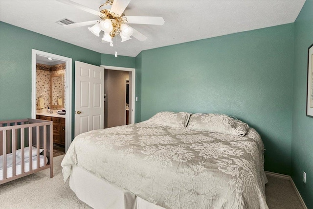 bedroom with carpet, ensuite bathroom, and ceiling fan