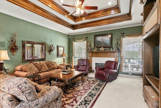 living room featuring light colored carpet, a raised ceiling, ceiling fan, and crown molding