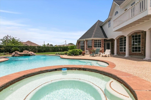 view of swimming pool featuring an in ground hot tub