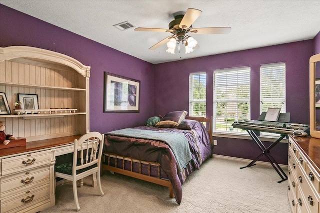 bedroom with a textured ceiling, ceiling fan, and light carpet