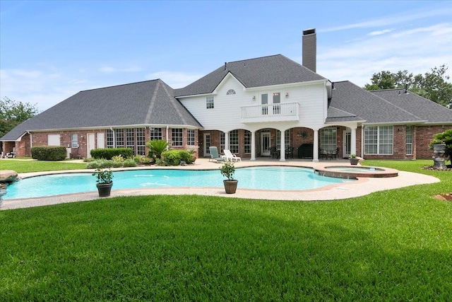 view of pool featuring a patio area, a yard, and an in ground hot tub