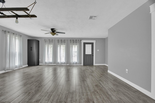 foyer featuring a wealth of natural light, ceiling fan, and dark wood-type flooring