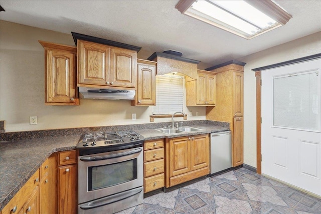 275 E Clover Ln, Bridge City, TX 77611 - kitchen with stainless steel appliances, under cabinet range hood, a sink, and dark countertops