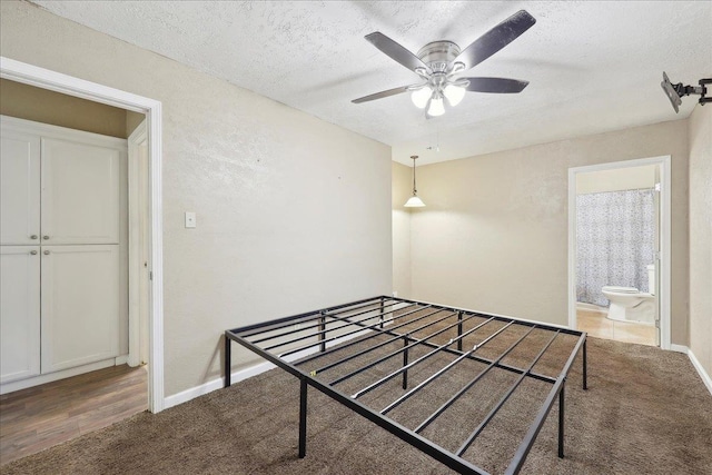 275 E Clover Ln, Bridge City, TX 77611 - unfurnished bedroom featuring a textured ceiling, carpet flooring, baseboards, ensuite bathroom, and ceiling fan