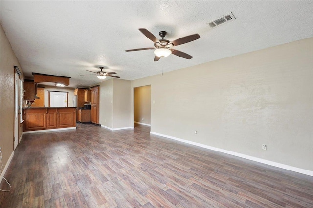 275 E Clover Ln, Bridge City, TX 77611 - unfurnished living room featuring dark wood-type flooring, a ceiling fan, baseboards, and a textured ceiling