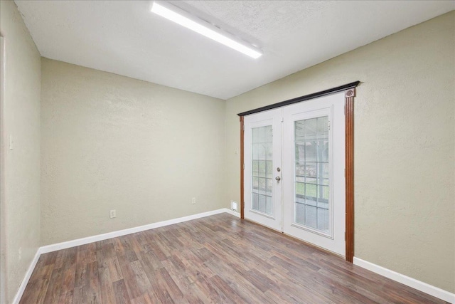 275 E Clover Ln, Bridge City, TX 77611 - unfurnished room with wood finished floors, french doors, a textured wall, and baseboards