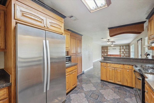 275 E Clover Ln, Bridge City, TX 77611 - kitchen featuring stainless steel appliances, dark countertops, a ceiling fan, and baseboards