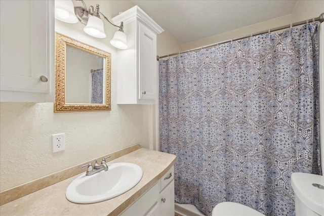 275 E Clover Ln, Bridge City, TX 77611 - full bath with toilet, vanity, a textured wall, and a shower with shower curtain