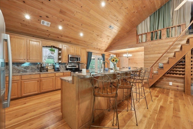 9570 Skeeter Dr, Orange, TX 77632 - kitchen with appliances with stainless steel finishes, wooden ceiling, plenty of natural light, a breakfast bar, and light wood-style flooring