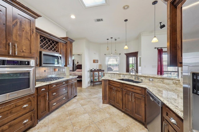 640 Winchester Dr, Bridge City, TX 77611 - kitchen featuring appliances with stainless steel finishes, a sink, crown molding, tasteful backsplash, and pendant lighting