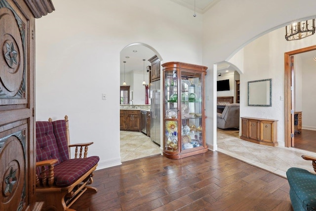 640 Winchester Dr, Bridge City, TX 77611 - sitting room featuring arched walkways, light wood-style flooring, crown molding, a fireplace, and baseboards
