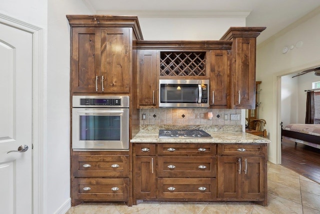 640 Winchester Dr, Bridge City, TX 77611 - kitchen with stainless steel appliances, ornamental molding, tasteful backsplash, light stone countertops, and baseboards