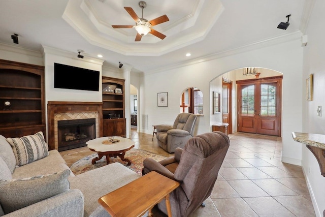 640 Winchester Dr, Bridge City, TX 77611 - living area with arched walkways, crown molding, light tile patterned floors, a tile fireplace, and baseboards