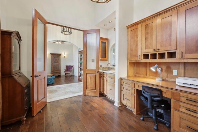 640 Winchester Dr, Bridge City, TX 77611 - office area with arched walkways, a sink, dark wood-style flooring, built in study area, and a high ceiling