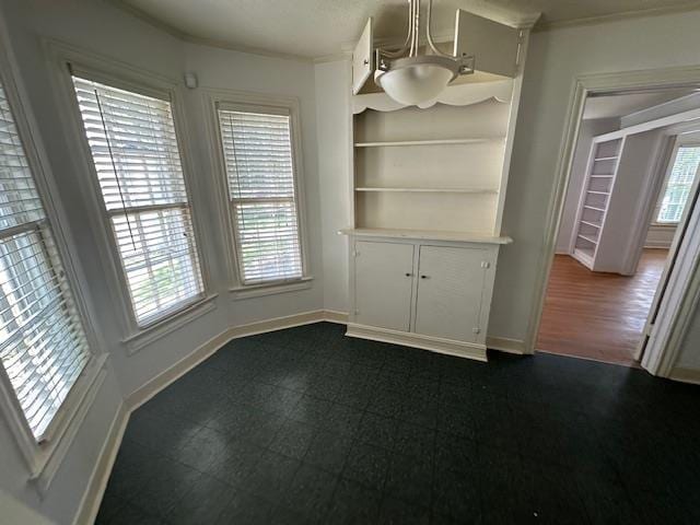 unfurnished dining area featuring built in features and a notable chandelier