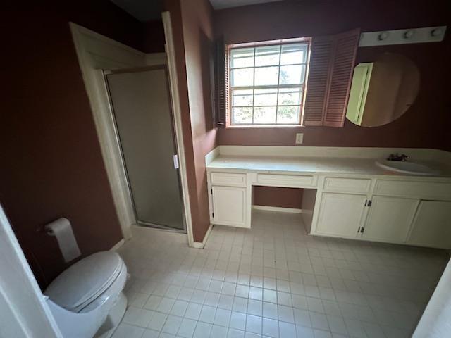 bathroom featuring vanity, an enclosed shower, and toilet