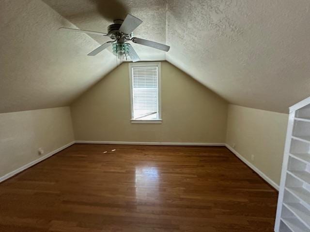 bonus room featuring a textured ceiling, lofted ceiling, ceiling fan, and dark hardwood / wood-style floors