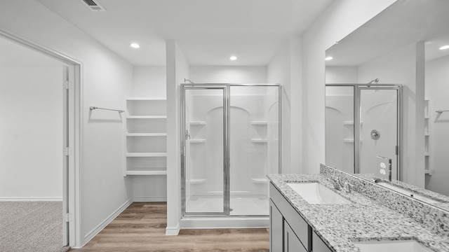 bathroom featuring vanity, wood-type flooring, and walk in shower