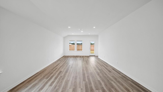 unfurnished living room with light hardwood / wood-style floors and lofted ceiling