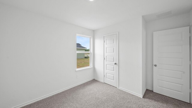 unfurnished bedroom featuring carpet flooring and a closet