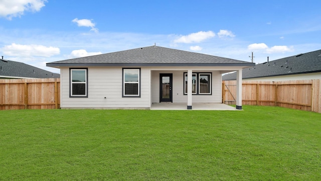 back of property with a lawn and a patio