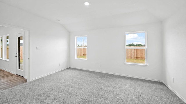 carpeted spare room with lofted ceiling and a wealth of natural light