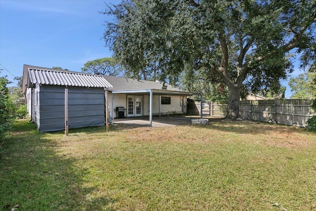 back of property with a yard and french doors