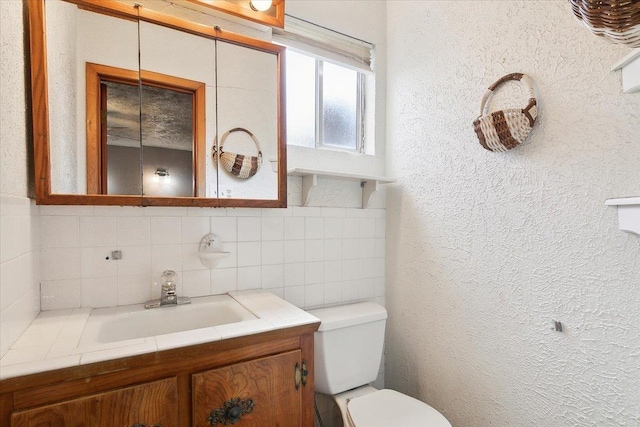 bathroom featuring vanity, toilet, and decorative backsplash