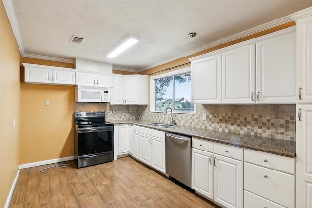 kitchen featuring white cabinetry, sink, appliances with stainless steel finishes, and dark stone counters