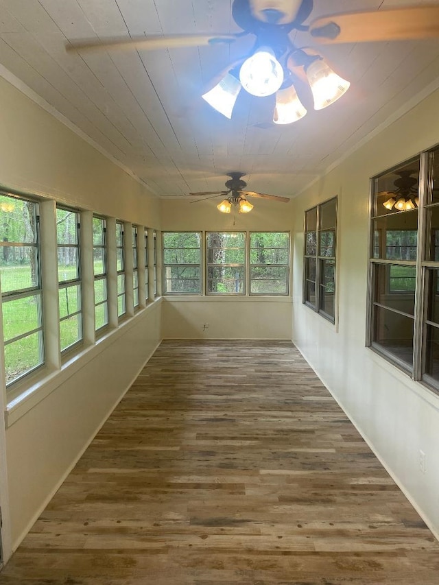 unfurnished sunroom featuring wood ceiling, ornamental molding, and wood finished floors