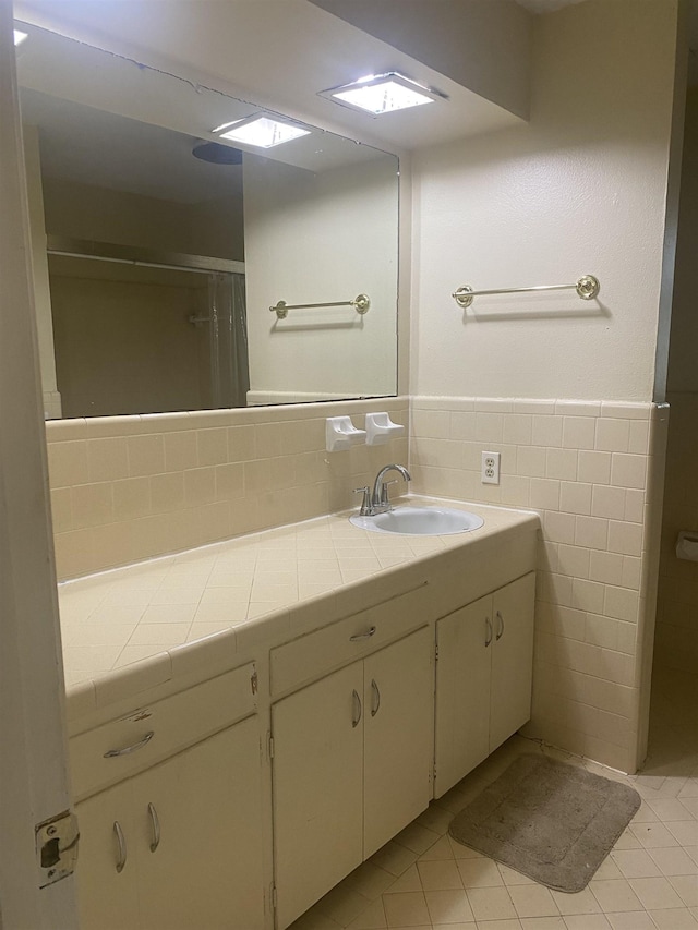 bathroom with a wainscoted wall, vanity, and tile walls