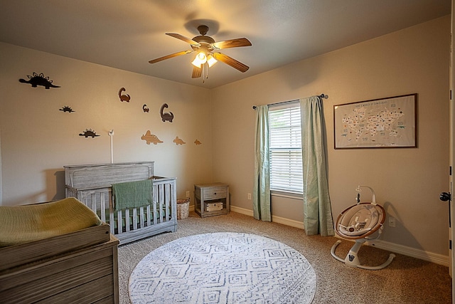 bedroom with ceiling fan, carpet floors, and a nursery area