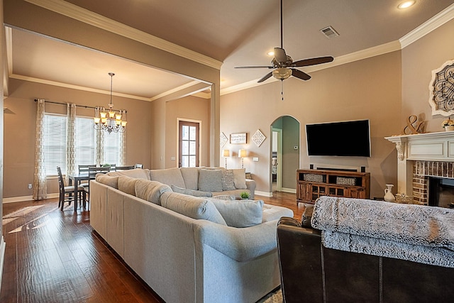 living room featuring a fireplace, ornamental molding, ceiling fan with notable chandelier, and a healthy amount of sunlight