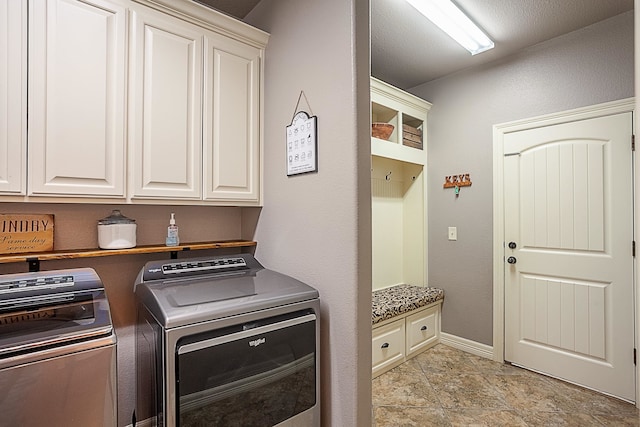 washroom featuring cabinets and washer and clothes dryer