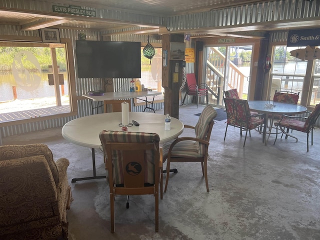 dining space featuring a healthy amount of sunlight and concrete flooring