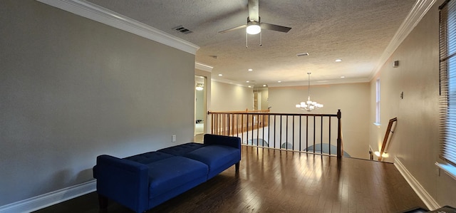 sitting room featuring ceiling fan with notable chandelier, dark hardwood / wood-style flooring, ornamental molding, and a textured ceiling