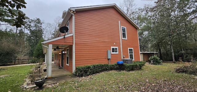 view of side of home featuring a lawn, a patio area, and ceiling fan