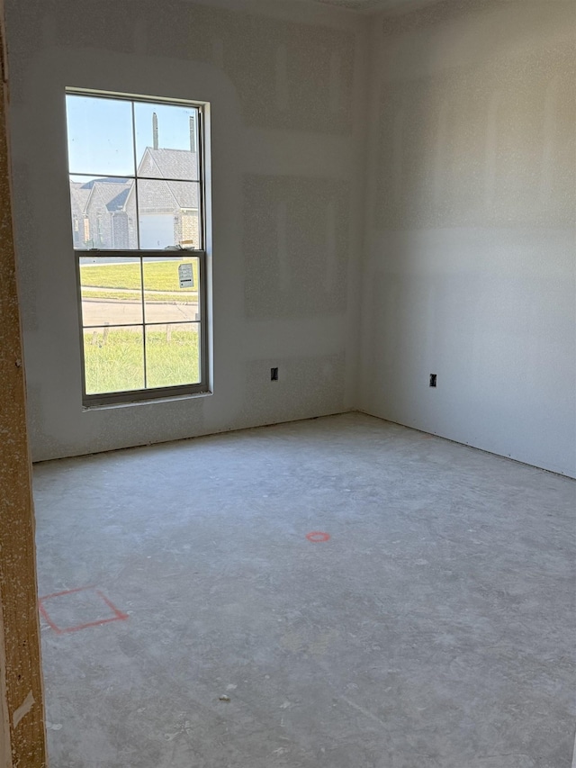 unfurnished room with concrete floors and a healthy amount of sunlight