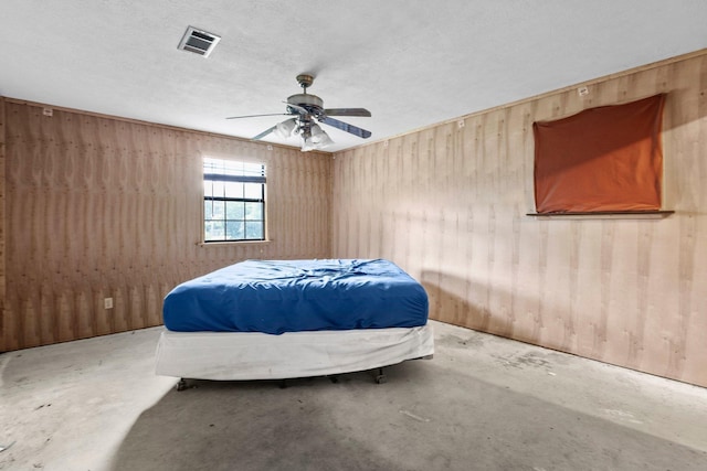 400 French Rd, Lumberton, TX 77657 - bedroom with concrete floors, wooden walls, and ceiling fan