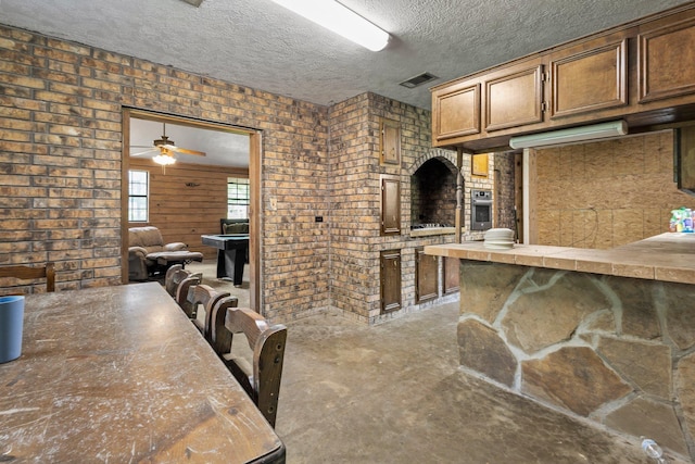 400 French Rd, Lumberton, TX 77657 - kitchen featuring oven, unfinished concrete floors, a ceiling fan, and a textured ceiling