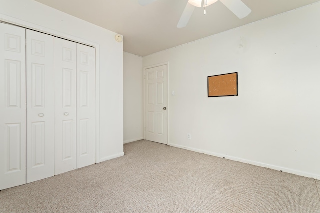 unfurnished bedroom with ceiling fan, light carpet, and a closet