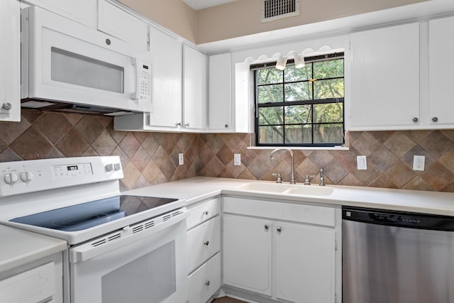 kitchen with white appliances, tasteful backsplash, white cabinetry, and sink